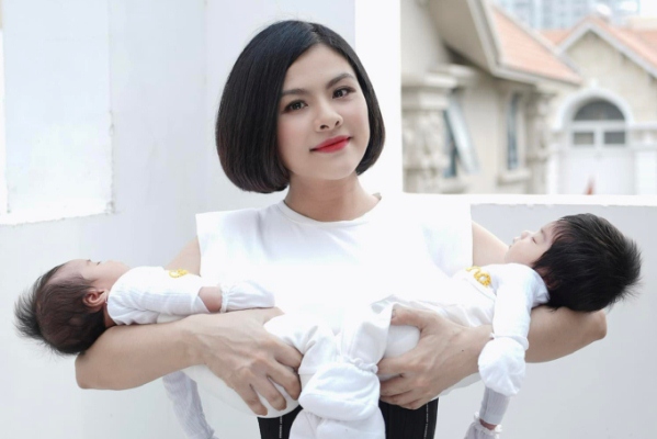 Vân Trang đeo nịt bụng siết eo khi bế cặp sinh đôi